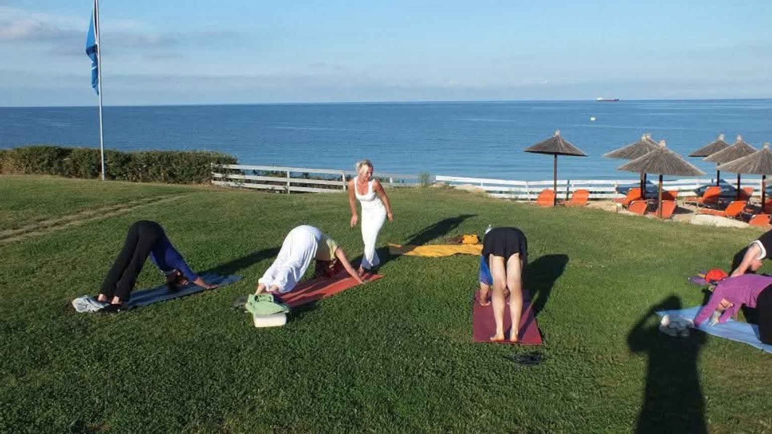 Yoga-Gruppe auf der Wiese am Meer auf Sardinien, historische Aufnahme von 2013