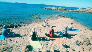 Yoga-Gruppe bei der Meditation am Strand von Sardinien, historische Aufnahme von 2013