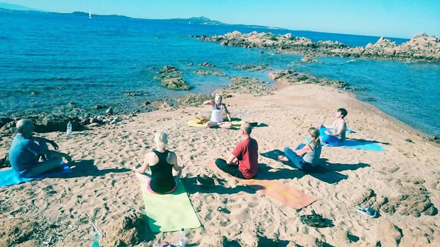 Yoga-Gruppe bei der Meditation am Strand von Sardinien, historische Aufnahme von 2013