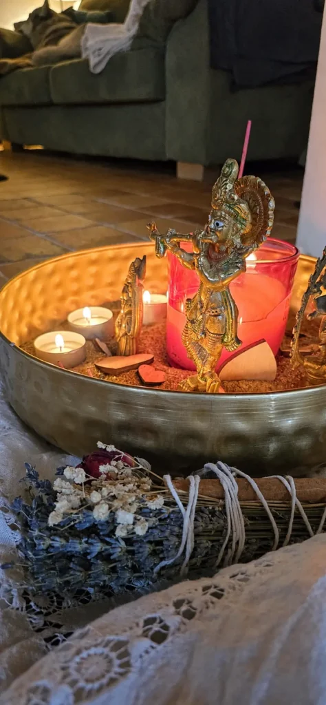 Kerzen, Krishna-Figur und Räucherwerk beim Yoga-Ritual