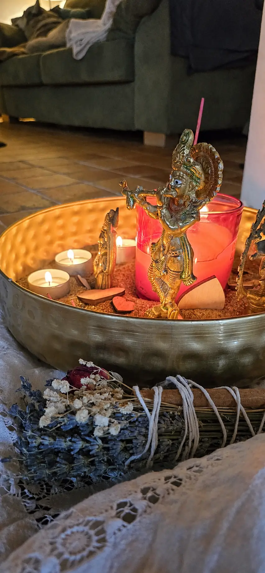 Kerzen, Krishna-Figur und Räucherwerk beim Yoga-Ritual