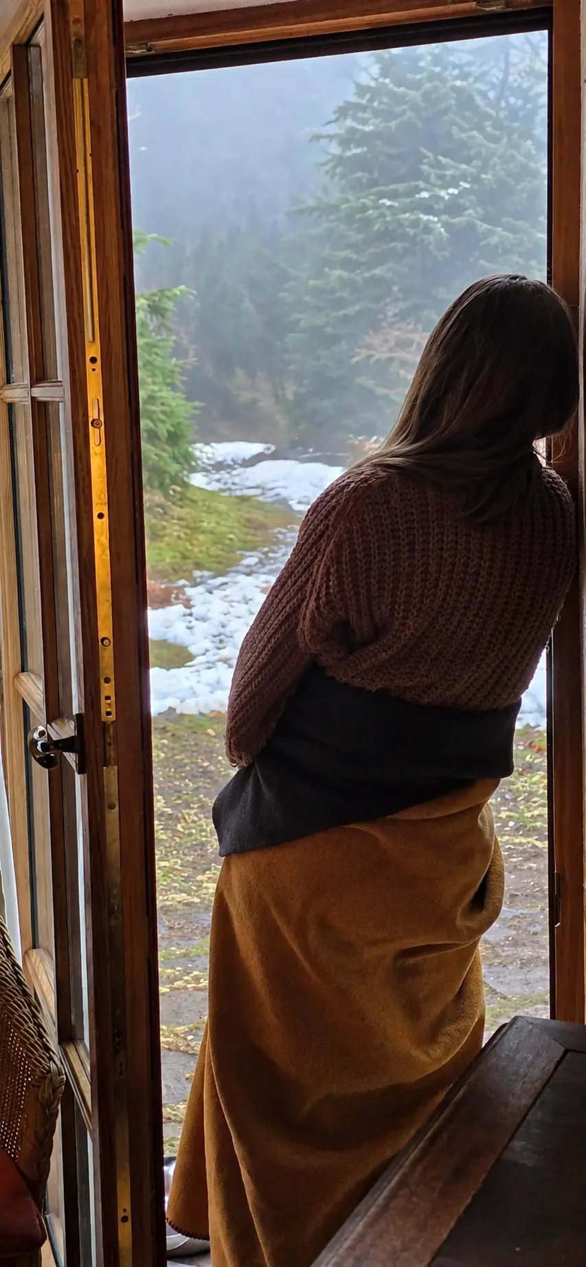 Achtsamer Blick aus der Bergbaude in die verschneite Natur